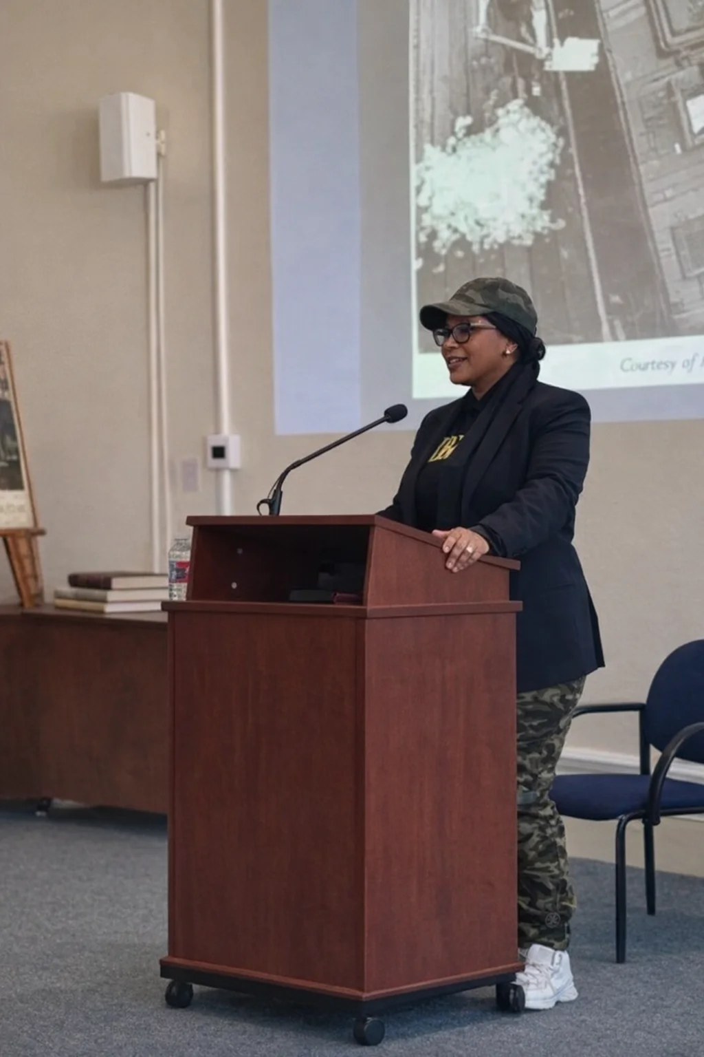 Aisha Abdul Rahman speaking at a podium during a genealogy and heritage presentation
